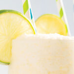 Lime Slushy drink with two straws and lime garnish